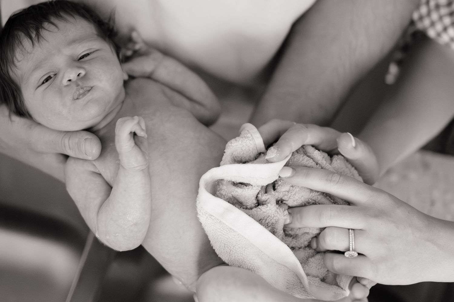 newborn baby being wrapped in towel after bath