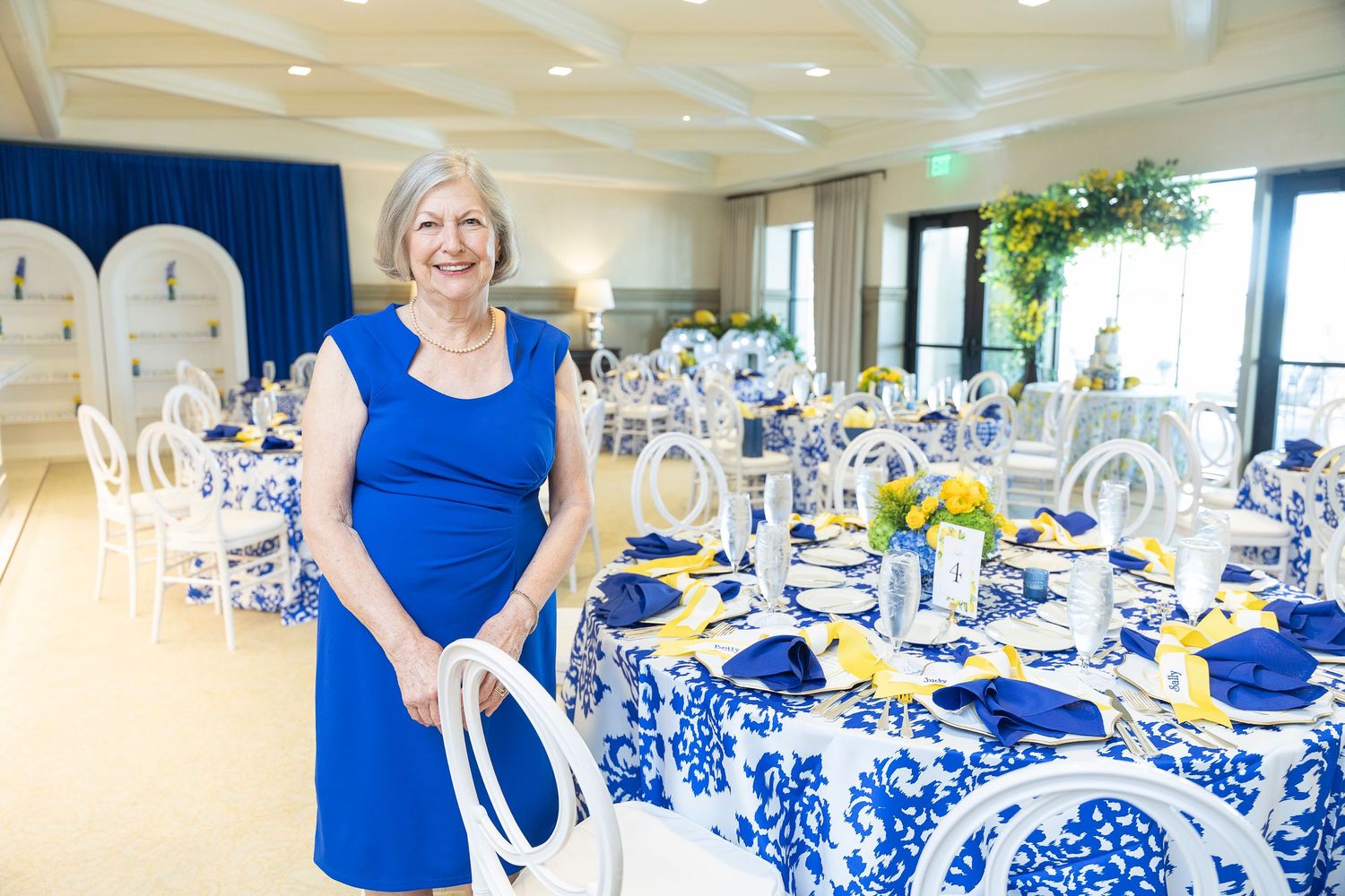 Wedding reception venue decorated with blue and white floral tablecloths and elegant place settings.