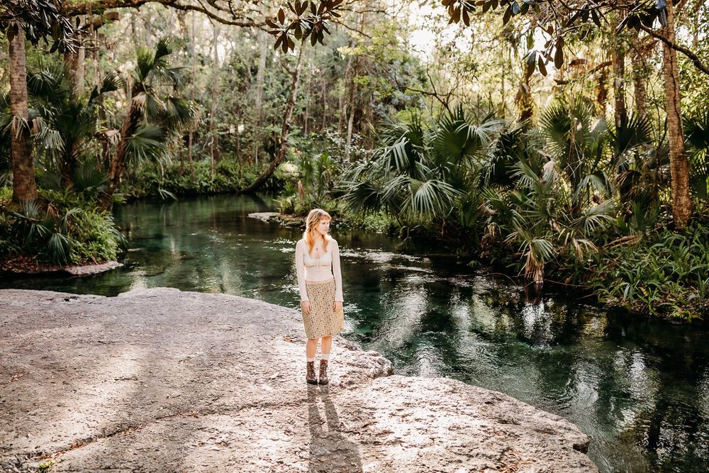 A serene forest spring with crystal clear turquoise water flows peacefully through a wooded natural setting.