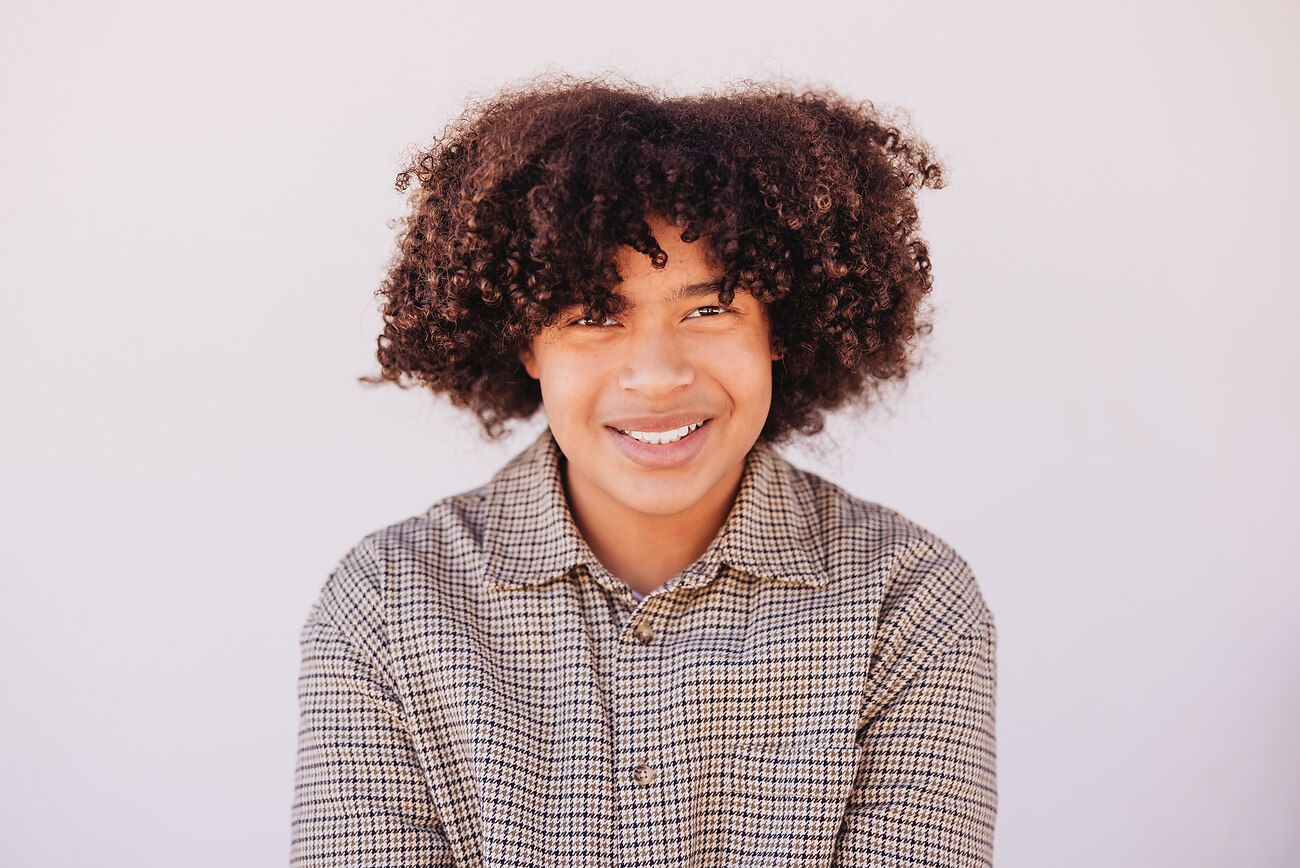 Black and white portrait series showing a child's expressions ranging from serious to joyful.