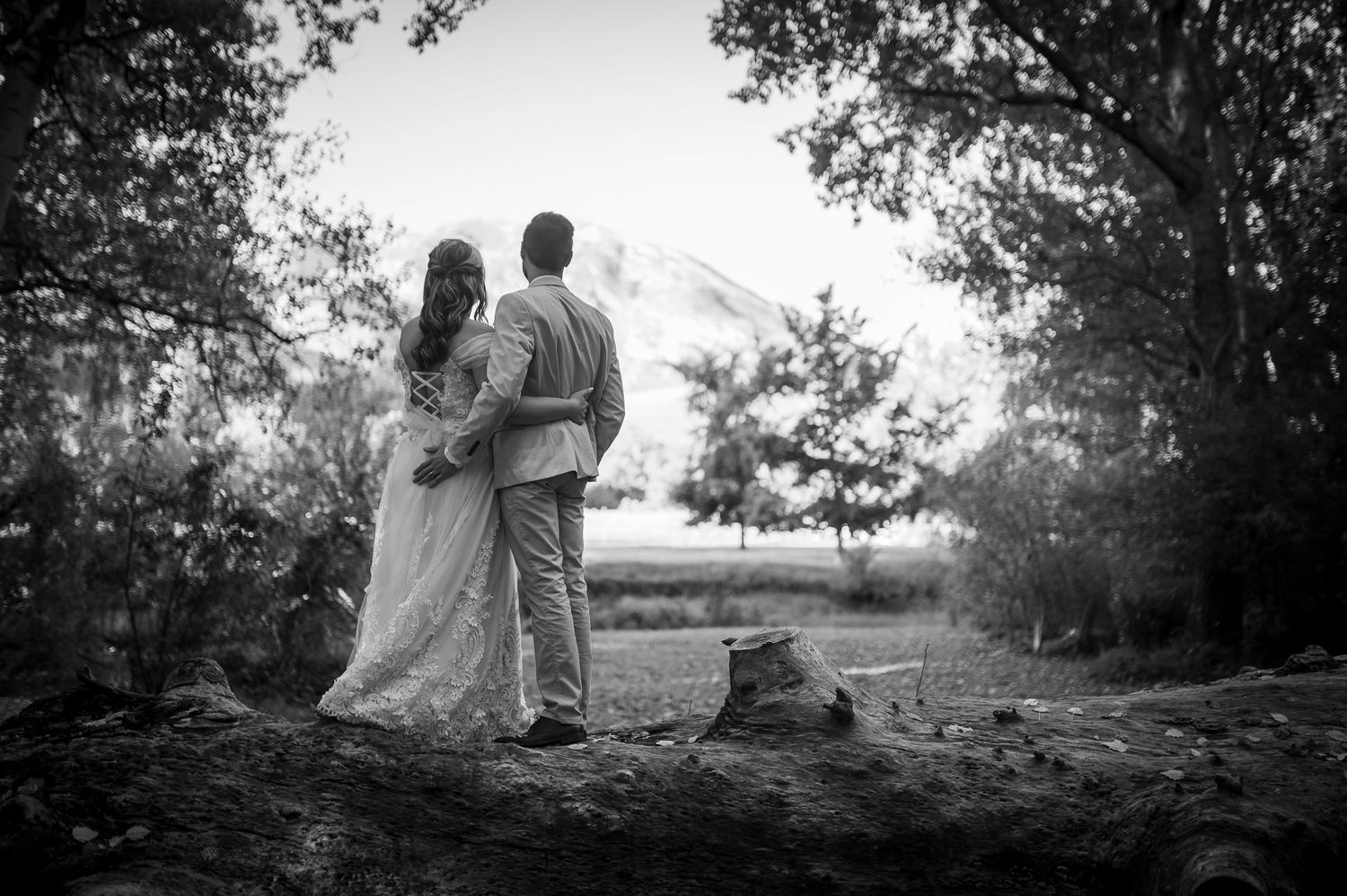 A romantic black and white landscape photo showing a couple embracing while looking at Mount Hood in Oregon.