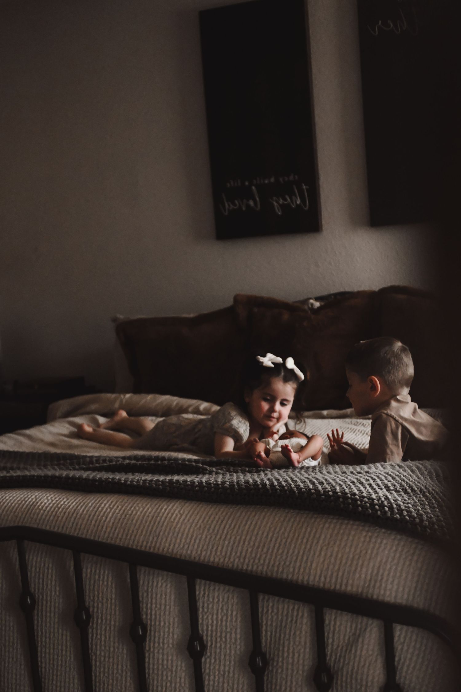 Dark moody image of a cozy textured bed with grey knit blanket.