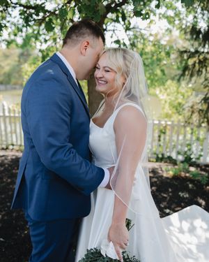 A couple sharing an intimate first look moment in a garden setting during their wedding day.