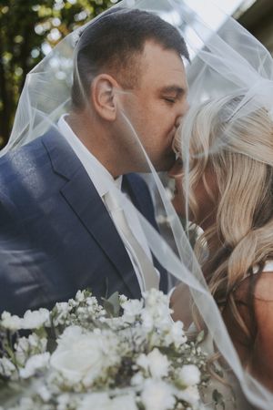 A romantic wedding moment captured in sequence showing the couple sharing a kiss under a delicate white veil.