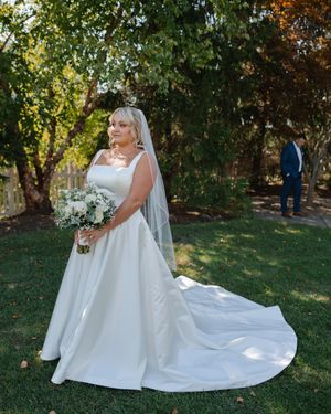 Elegant bridal portraits showcasing a flowing white wedding dress train in a garden setting.