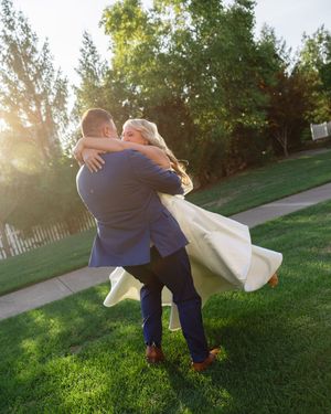 Playful wedding photos on a grassy lawn during golden hour with flowing white dress.
