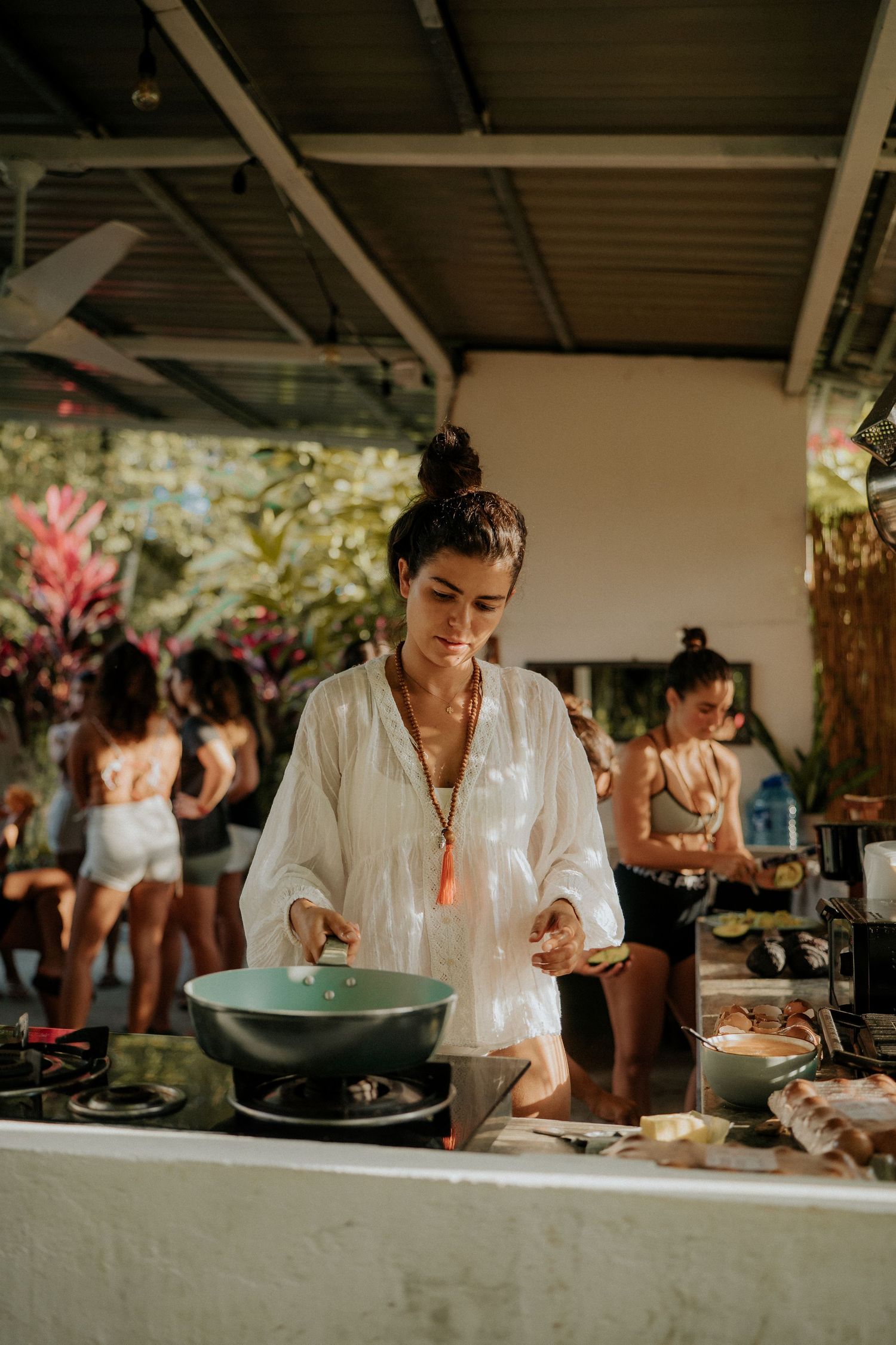 Chef preparing food at outdoor cooking station with bowls and ingredients.