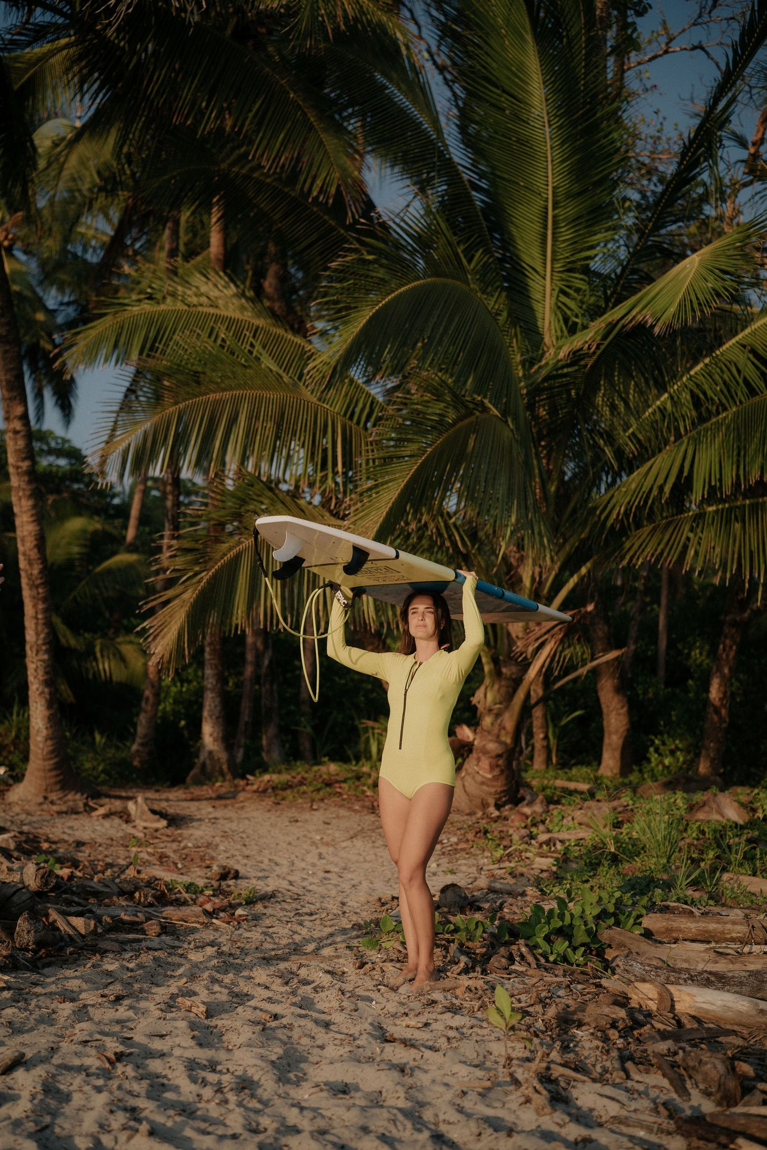 Series of surfing poses on a sandy beach with palm trees and ocean backdrop.