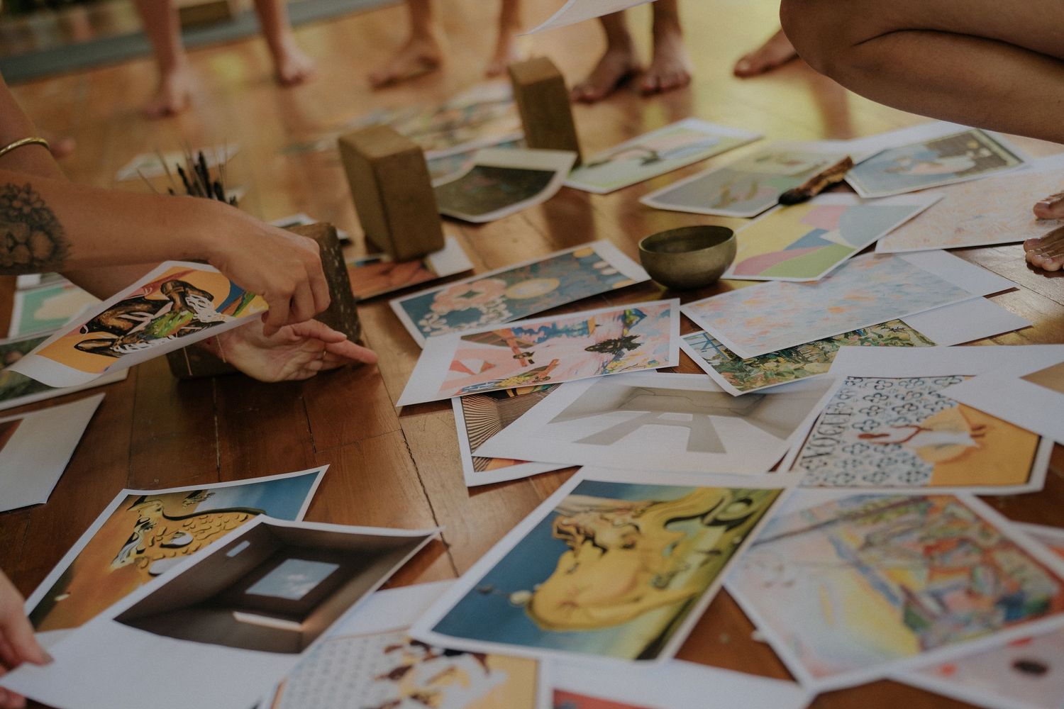 Collection of tarot cards spread across wooden table in warm lighting.