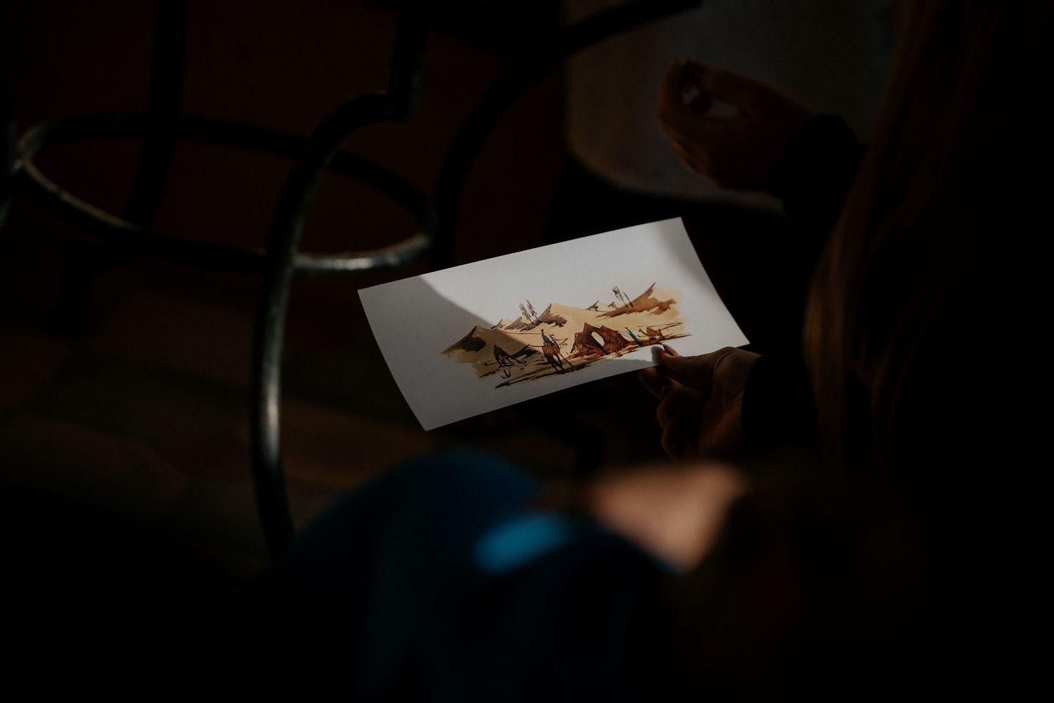 Close-up photograph of dried flowers on white paper in dark ambient lighting.