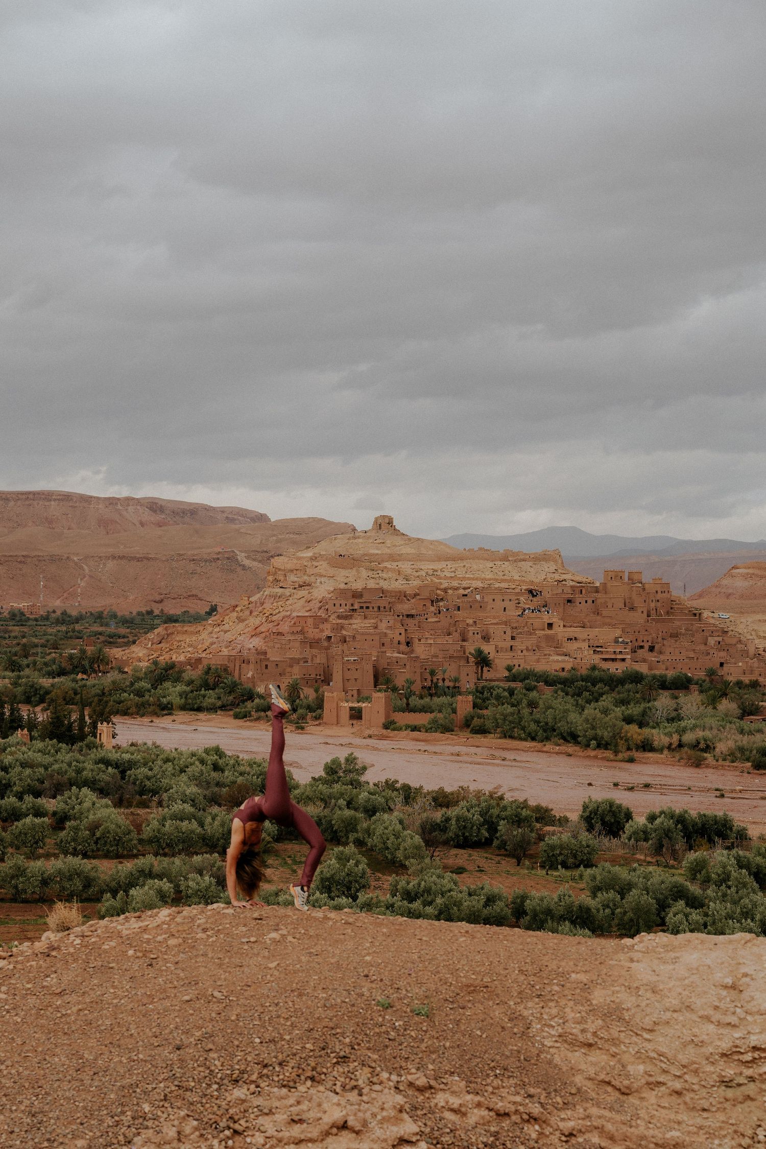 Panoramic view of ancient desert clay buildings nestled in arid mountain landscape.