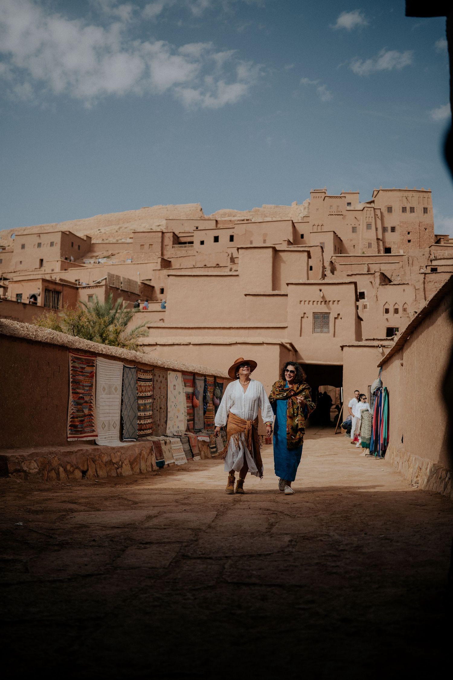 Traditional Moroccan street scene with clay buildings and storefronts in a desert village.