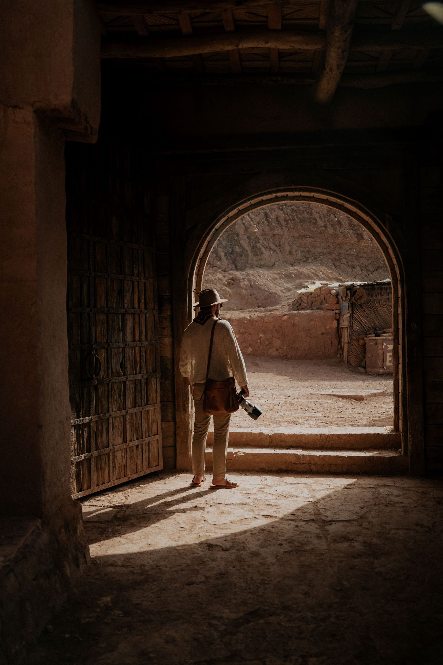 Beautiful archway frames view of ancient Moroccan fortress interior with dramatic lighting.