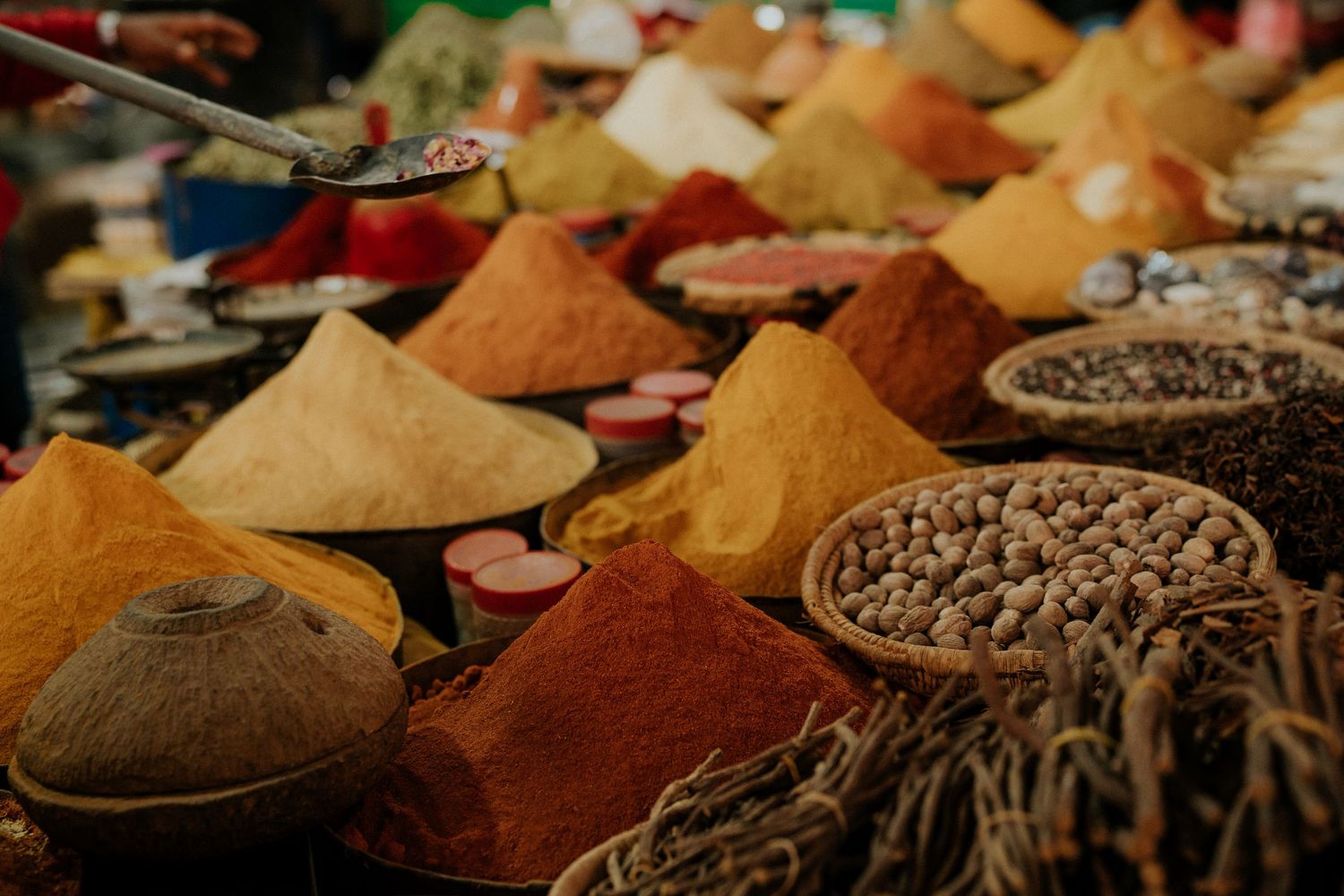 Colorful spices and seasonings in cone-shaped piles at a traditional market display.