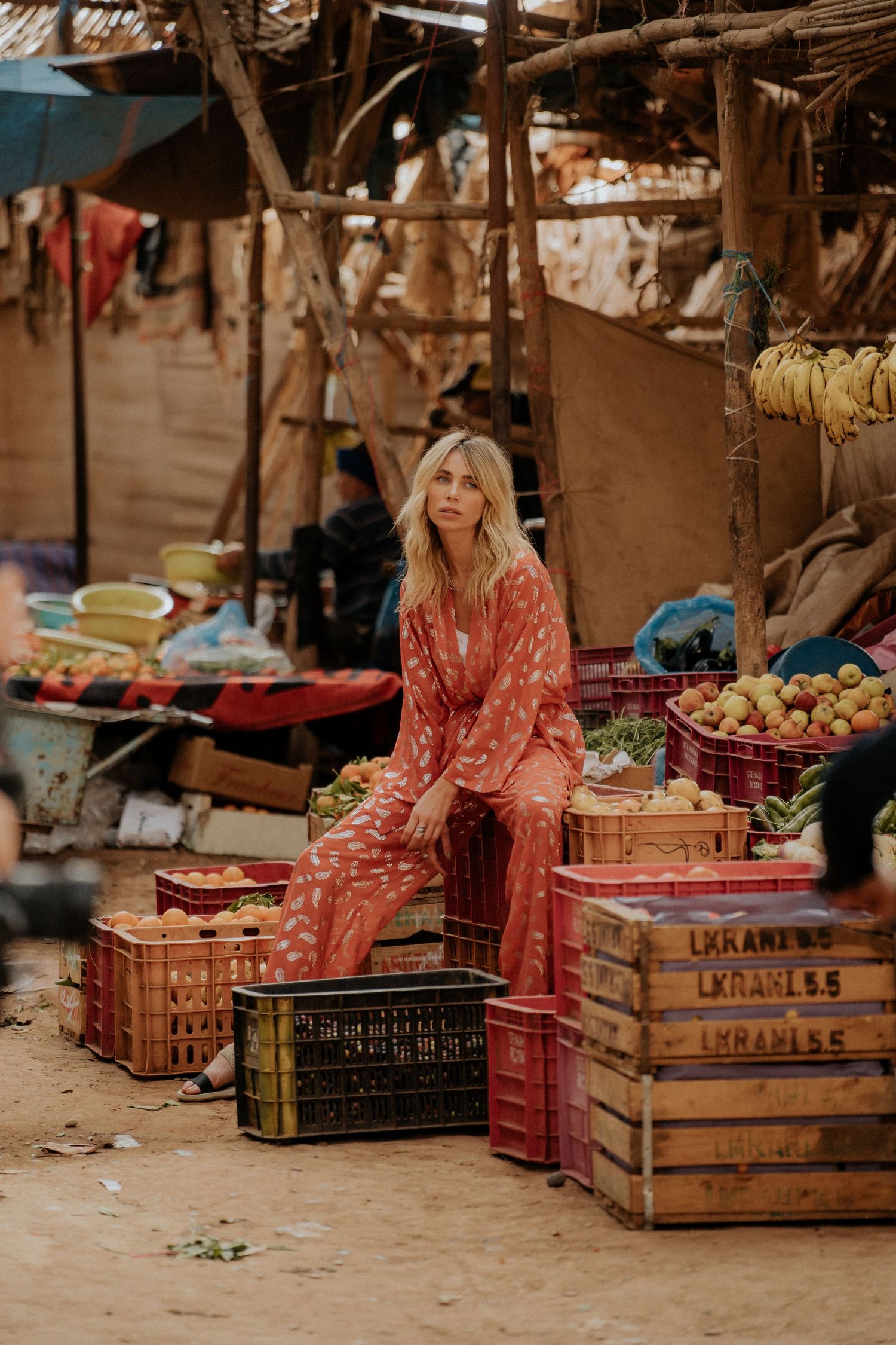 A market stall displays fresh produce and fruits in wooden crates.