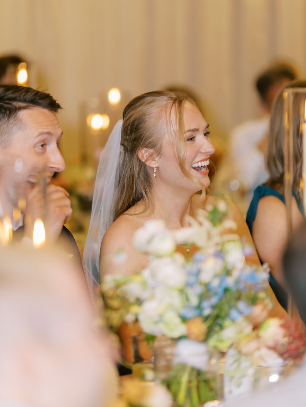 Elegant wedding reception table with blue and white floral centerpieces and soft ambient lighting.