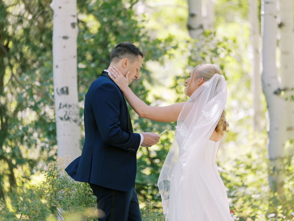 An intimate wedding moment captured in a sun-dappled aspen grove.