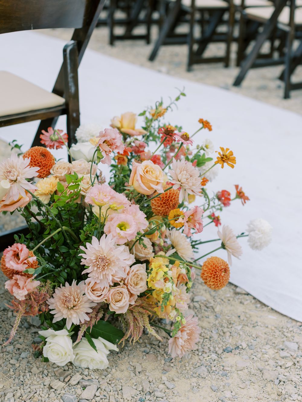 Elegant floral arrangements in peach, coral and blush tones adorn a wedding setting.