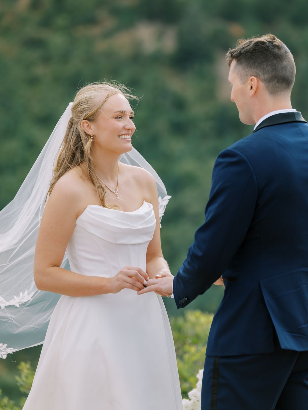 Joyful moment captured during a wedding ceremony against a natural outdoor backdrop.