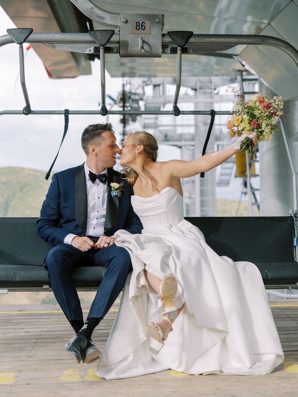 Newlyweds share intimate moments inside a modern ski lift cabin.