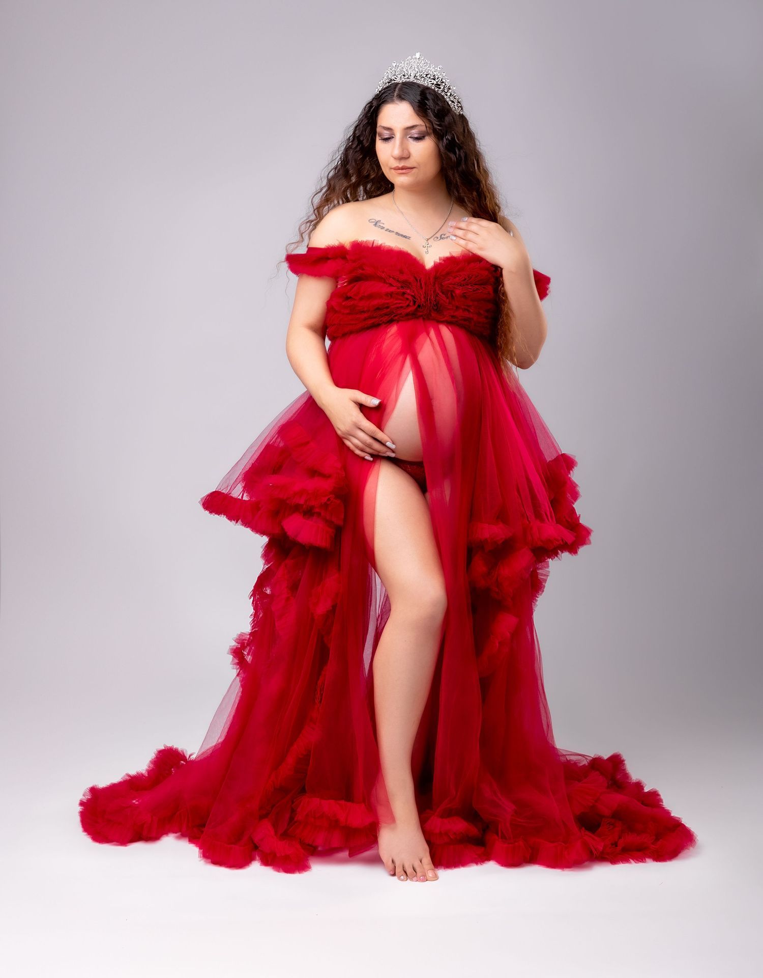 A figure in a flowing red tulle gown poses gracefully against a light gray studio backdrop in multiple artistic poses.