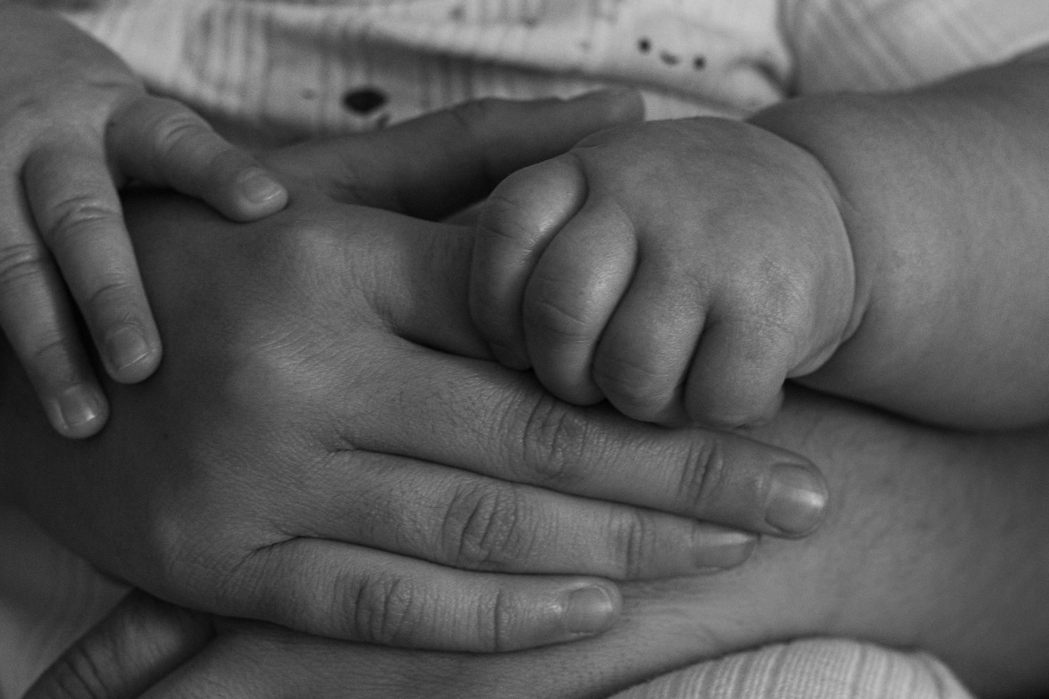 Close-up black and white image of gentle hands touching.