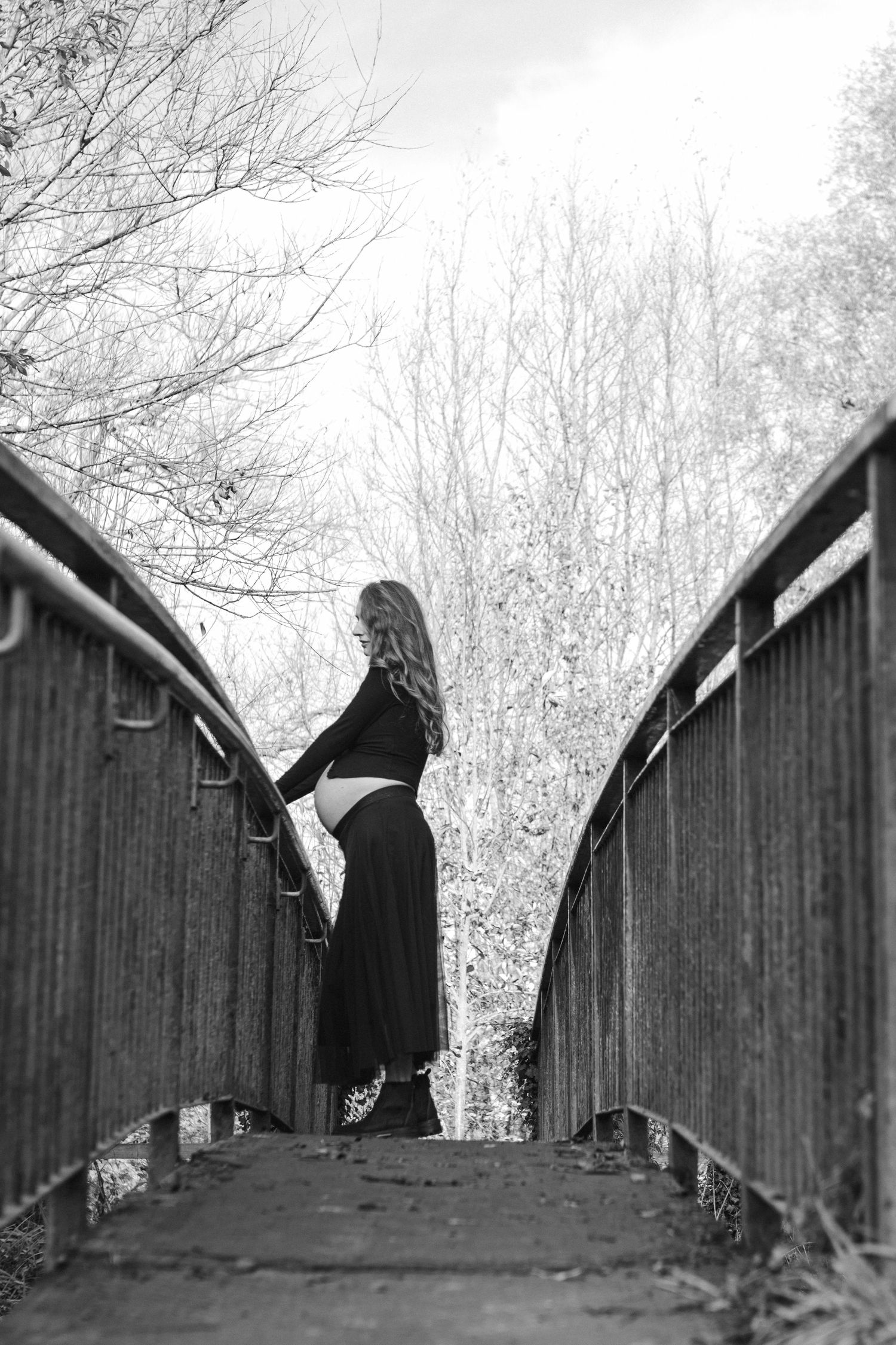 Silhouette on a wooden bridge captured in dramatic black and white.