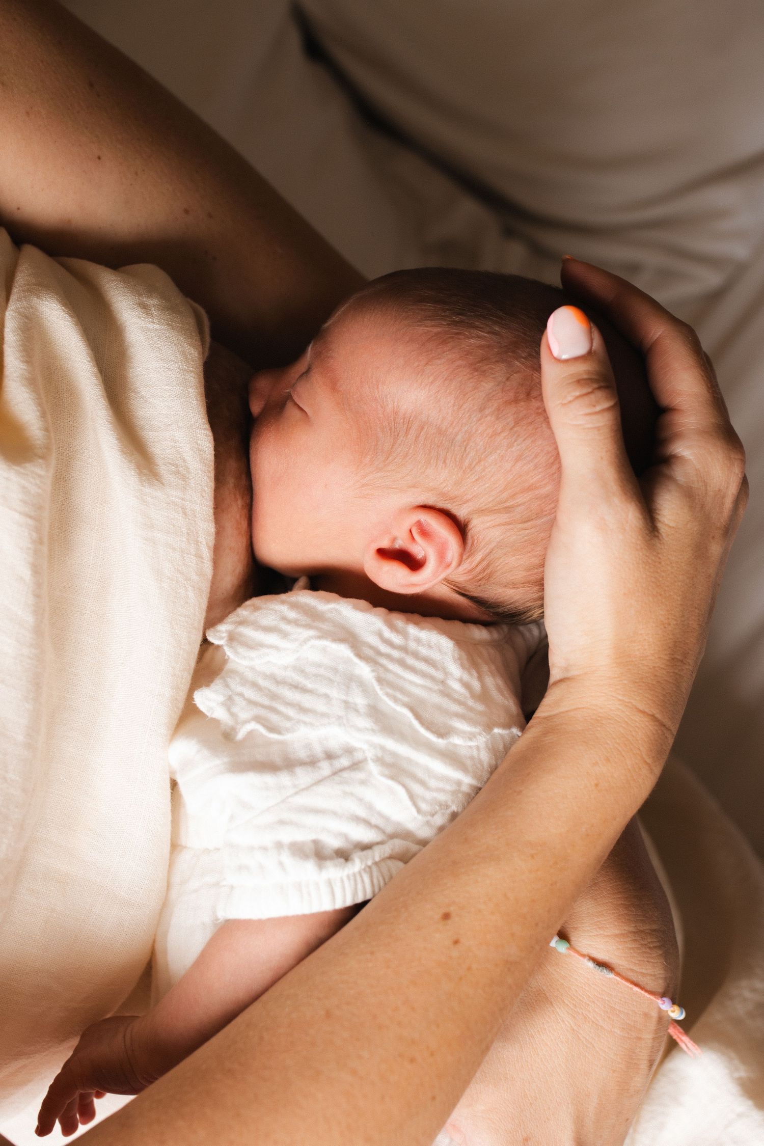 Intimate nursing moment captured in soft natural light.