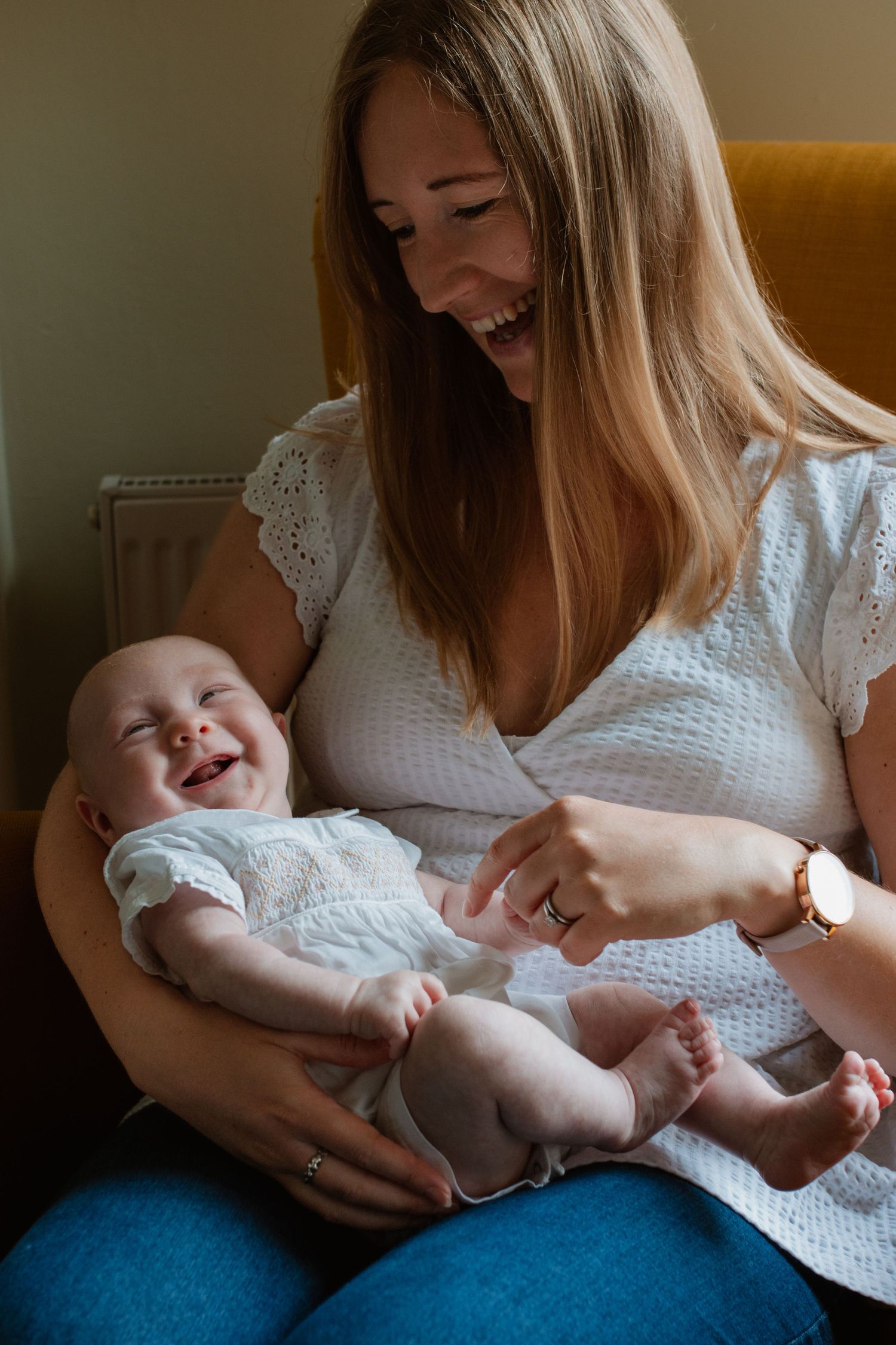 Candid moments of parent and baby interaction in natural window light.