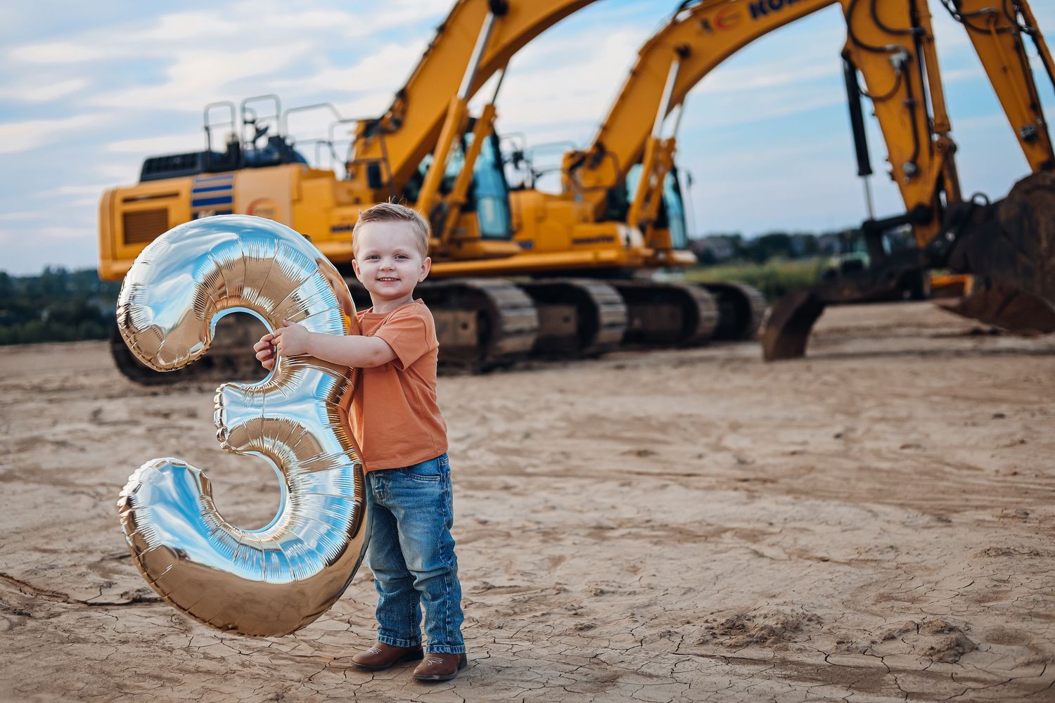 Row of yellow construction equipment on dirt site at sunset. Birthday milestone photography