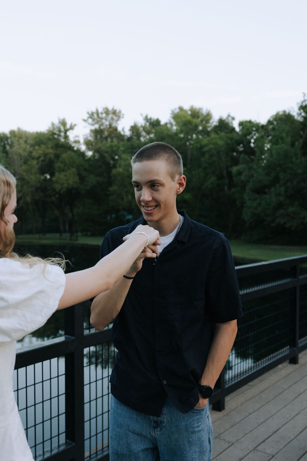 A playful interaction between a couple on a wooden deck with trees in the background.