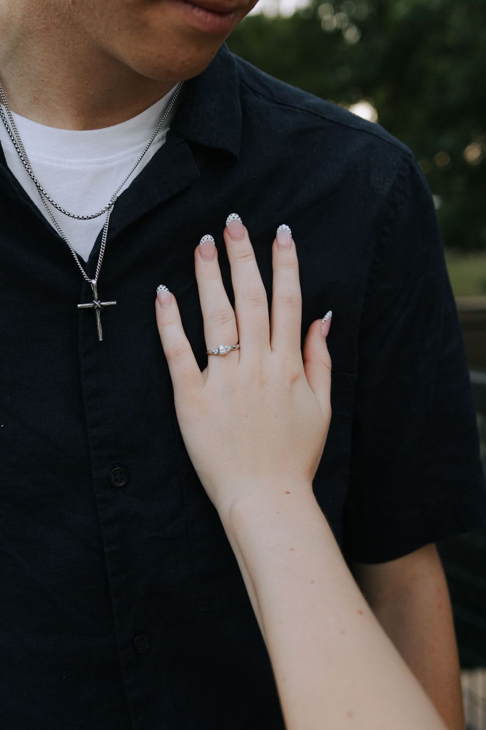 Close-up shots of hands touching a black shirt, showing intimate moments and details.