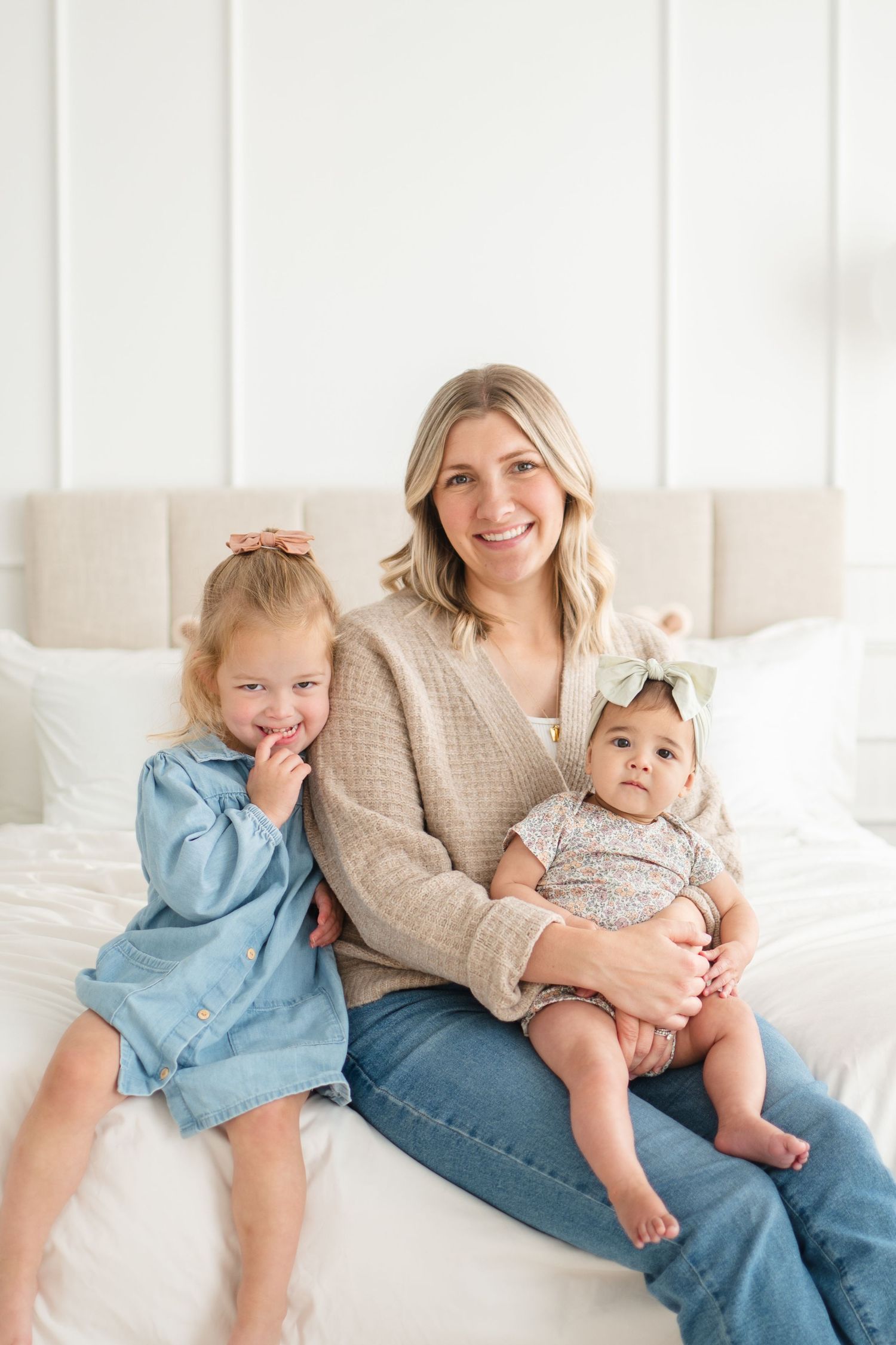 Family portrait series shows loving moments on a white couch in a bright, airy studio setting.