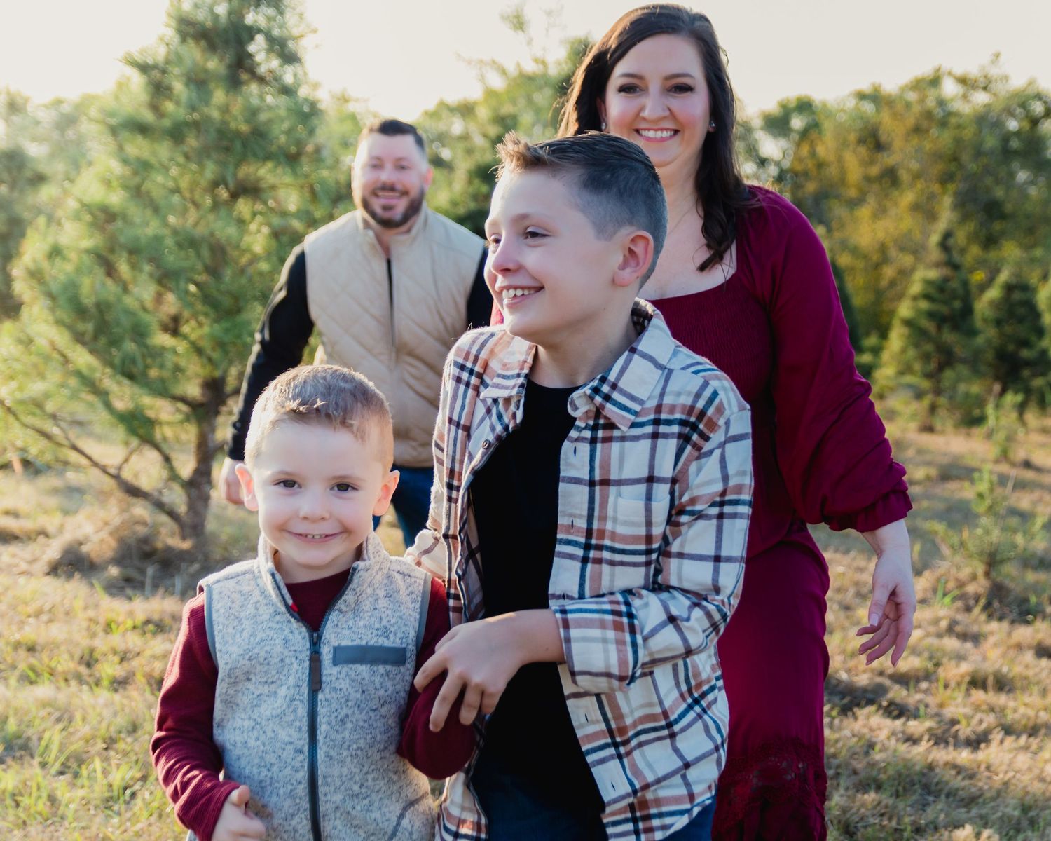 A happy family shares laughter and joy together outdoors during golden hour in a natural setting.