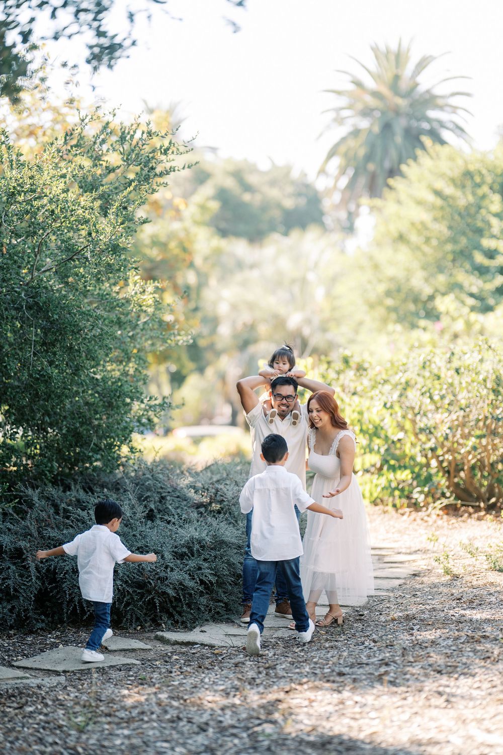 A sequence of candid family photos showing playful interactions in a sunny outdoor garden setting.