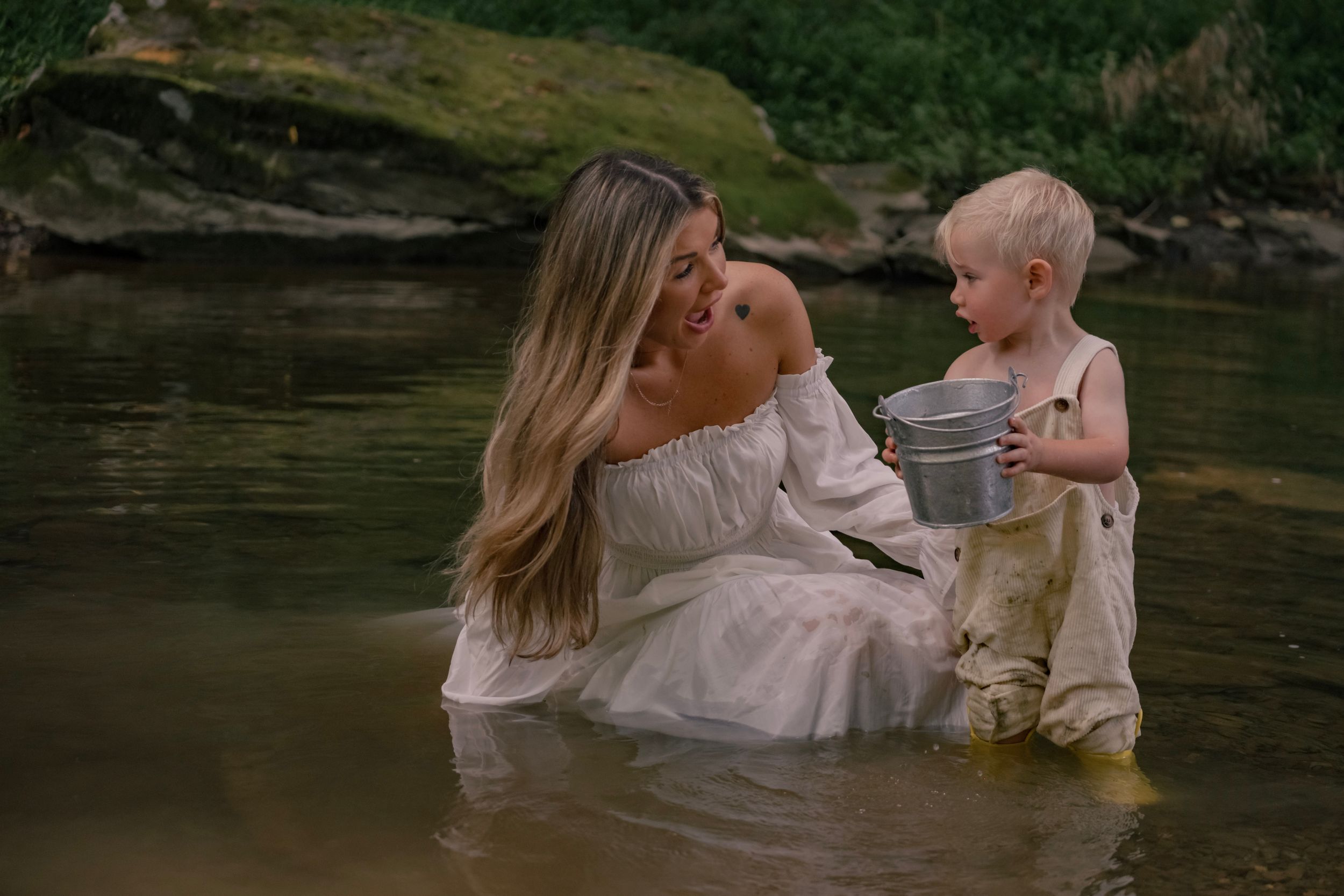 A playful moment captured in a creek with white dresses and boots creating a whimsical splash in nature.

Bentleyvile, PA