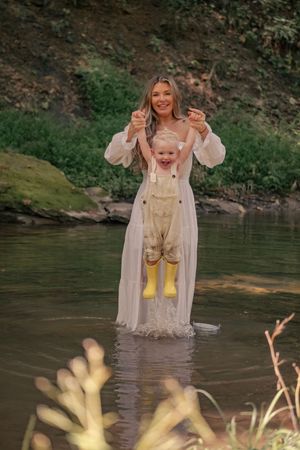 Someone wearing rain boots and a white dress wades through a shallow stream in a wooded area.

Pittsburgh, PA