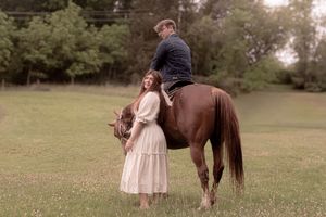 Outdoor photography session with horse in a pastoral setting.