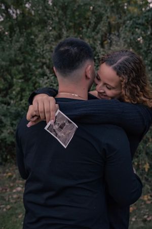 A sequence of intimate embraces between two people shown in four connected photos against a dark outdoor background.