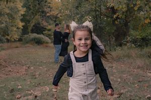 A series of five photos showing someone running and playing outdoors in a beige vest during autumn.
