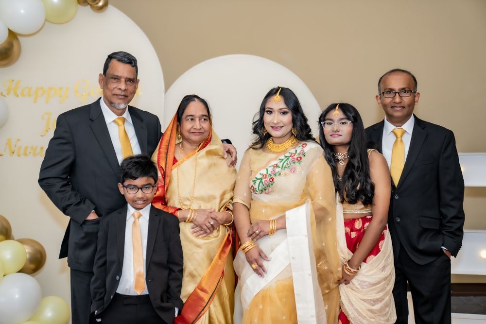 A group of people dressed in formal Indian attire gather together during a celebration event.