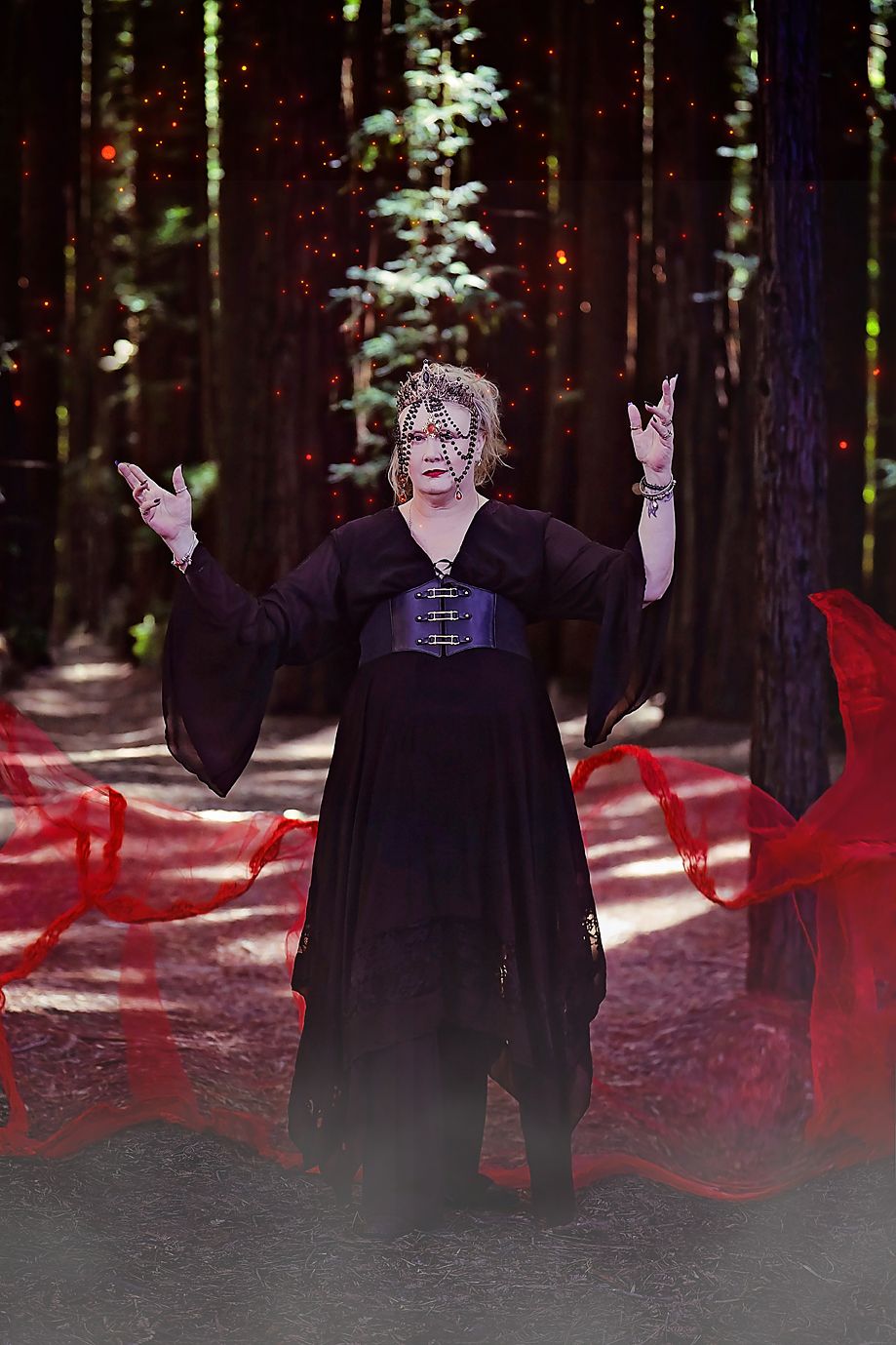 Artistic sequence of a figure in black clothing moving through a sunlit forest with red fabric flowing.