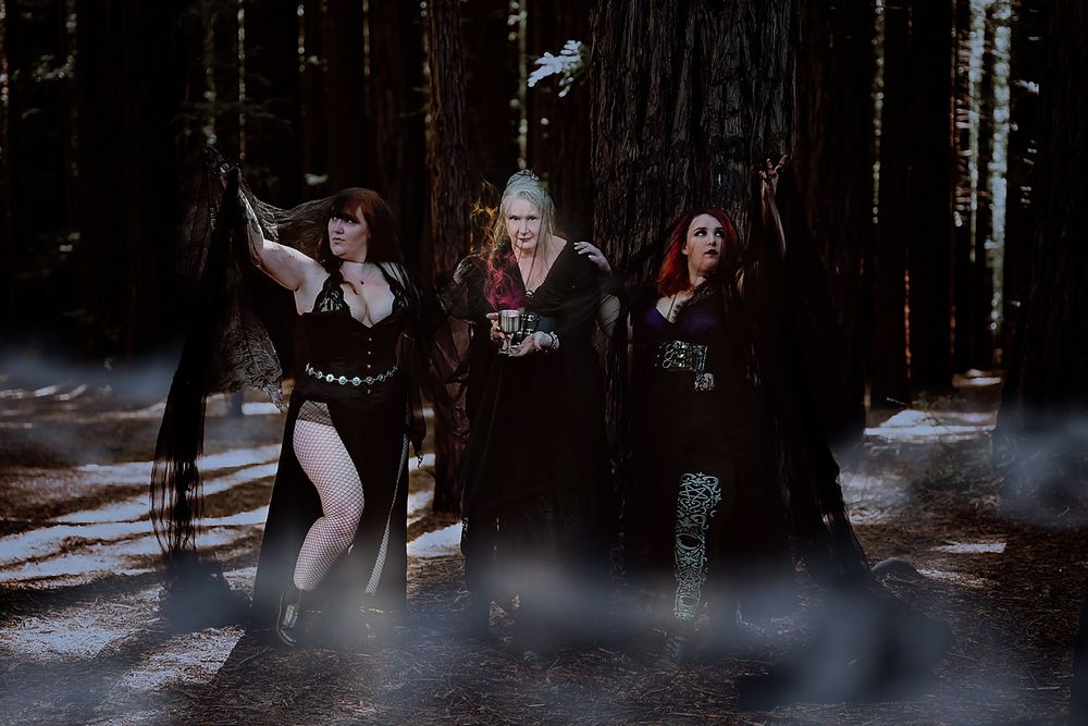 Three women celebrating themselves in a foggy redwood forest during a goddess photo session