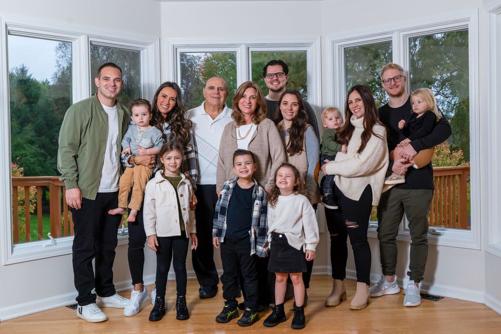 Several group portraits of people in casual and formal attire standing together in a white-walled room.