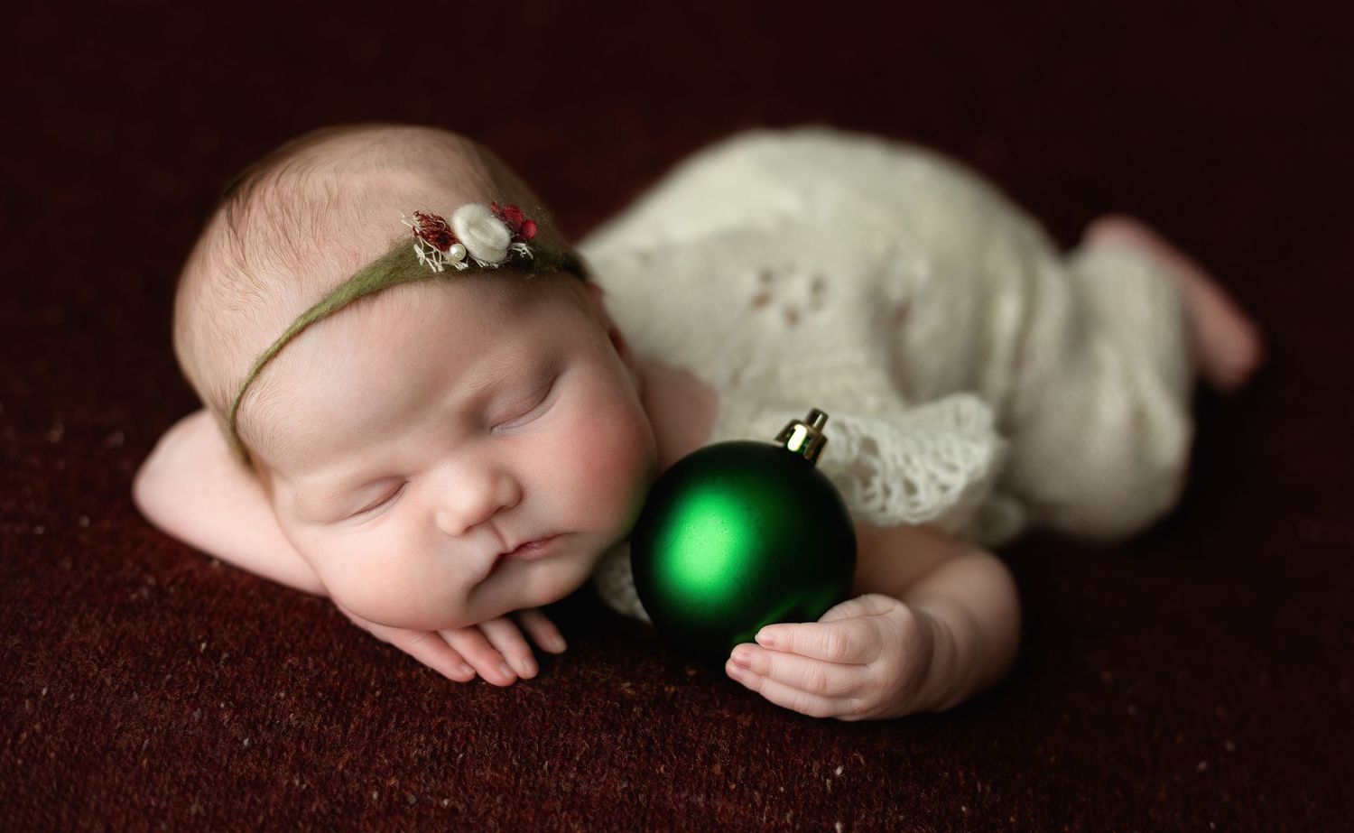 Newborn girl holding a Christmas bulb. Greenville SC newborn photographer, Easley, SC newborn photographer, Upstate newborn photographer