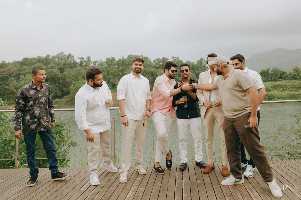 Wedding party poses on a wooden deck overlooking a scenic landscape.