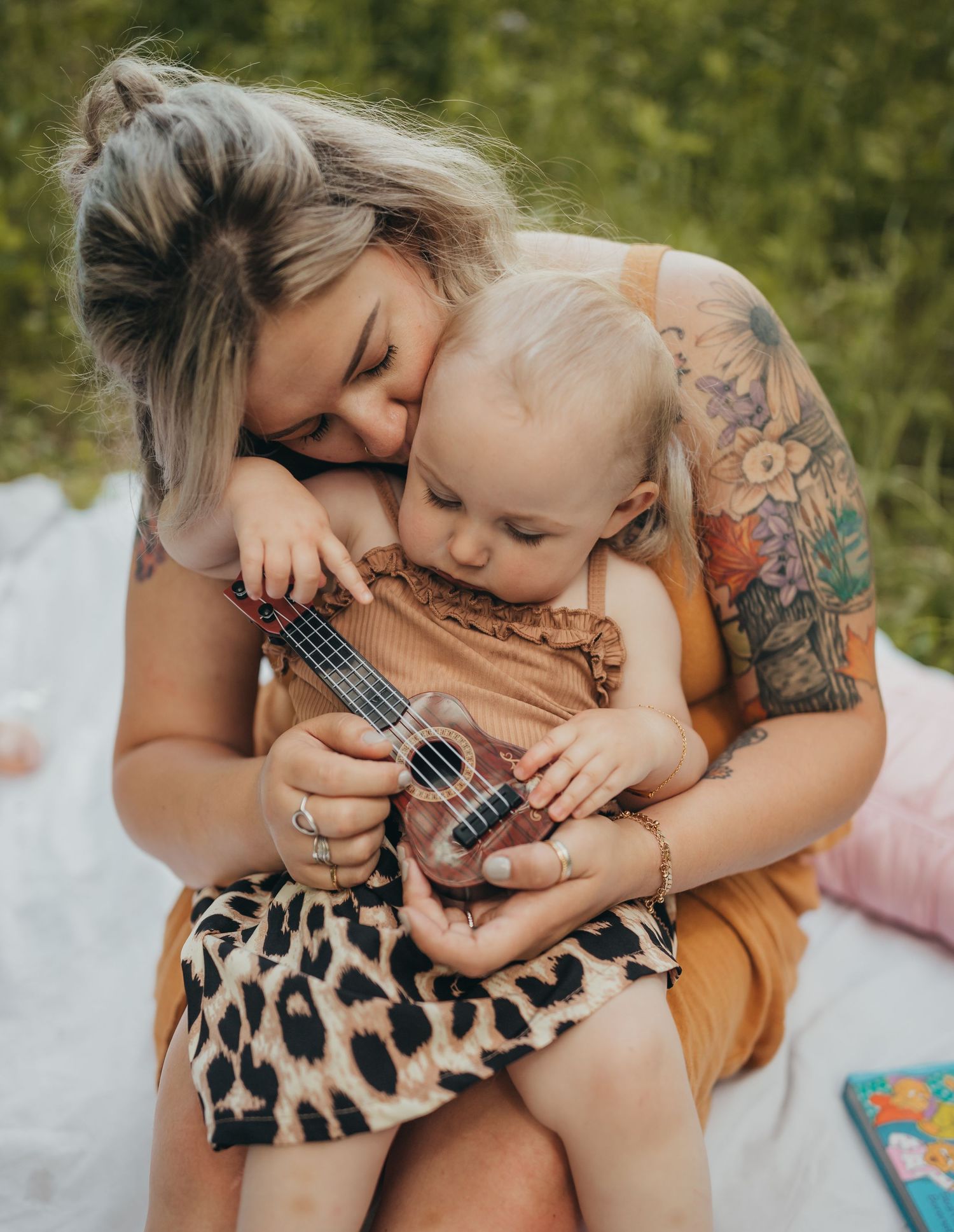 An intimate moment shared with a small child playing ukulele during an outdoor photoshoot.