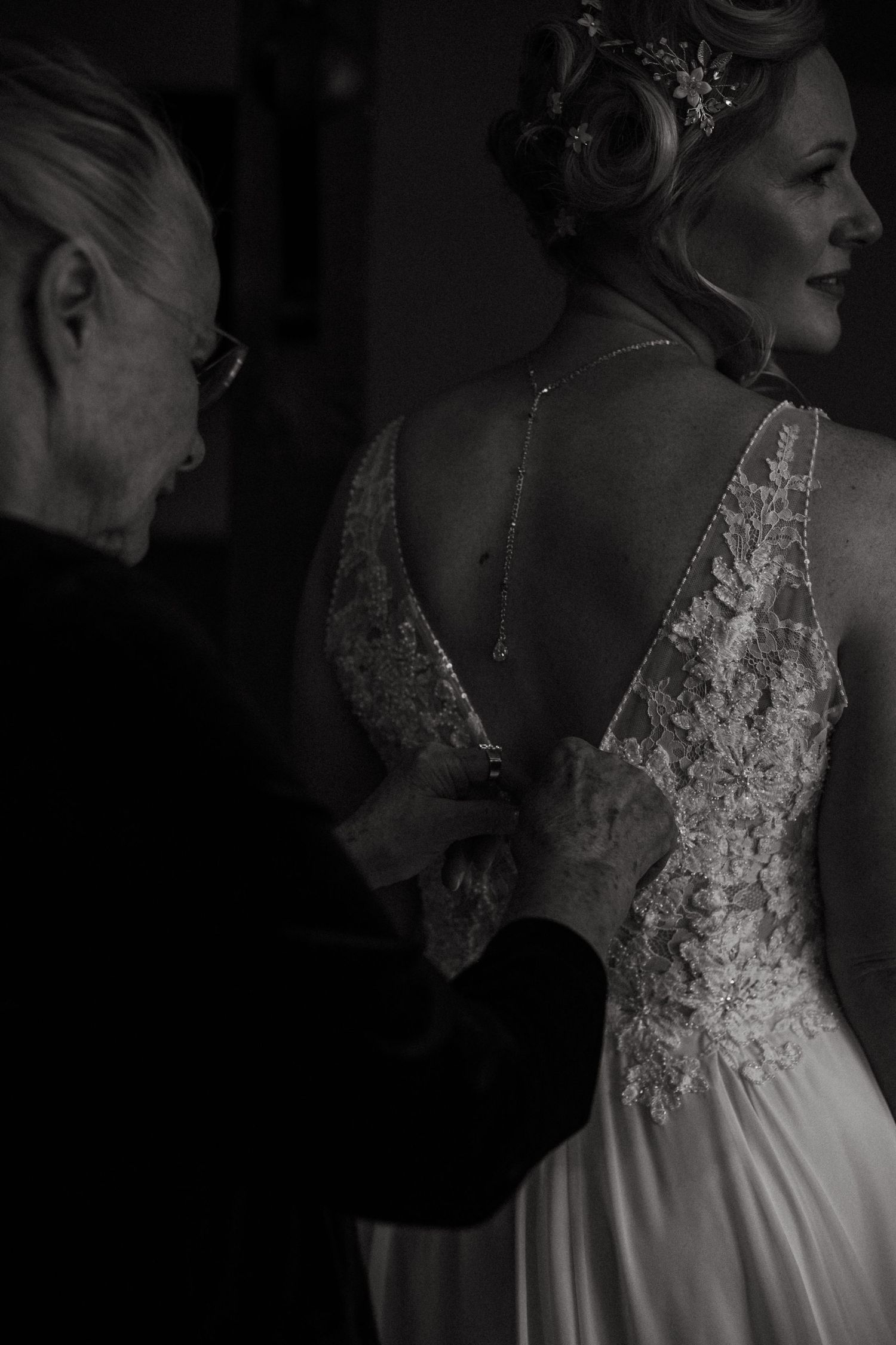 Close-up of intricate lace detailing on a white wedding gown bodice in black and white.