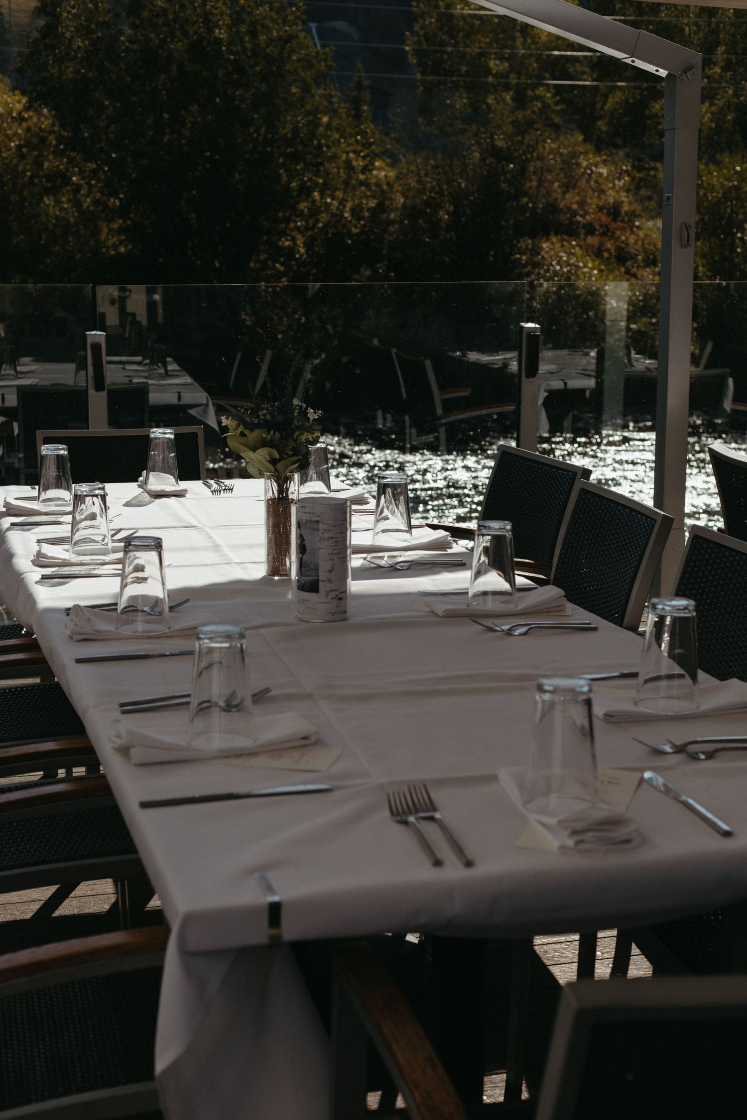 White tablecloths and place settings arranged in an elegant dining room.