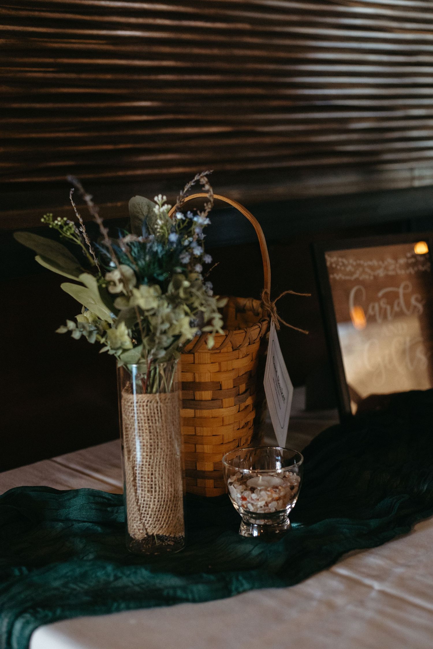 Rustic wedding centerpieces with burlap and flowers in woven baskets.